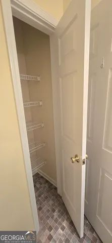 a view of a small space with wooden floor and a window