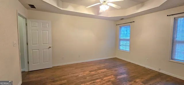 an empty room with wooden floor and closet