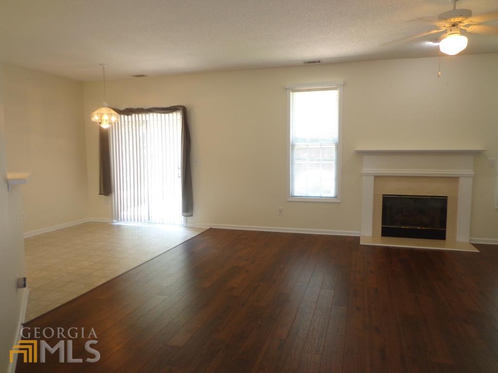 45 Chemin Place Sharpsburg, GA 30277 - Photo 2 of 26 an empty room with wooden floor fireplace and windows