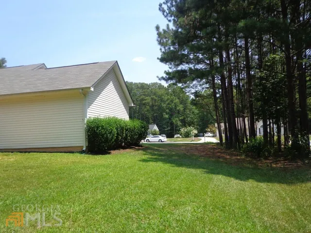 a view of a house with backyard and trees