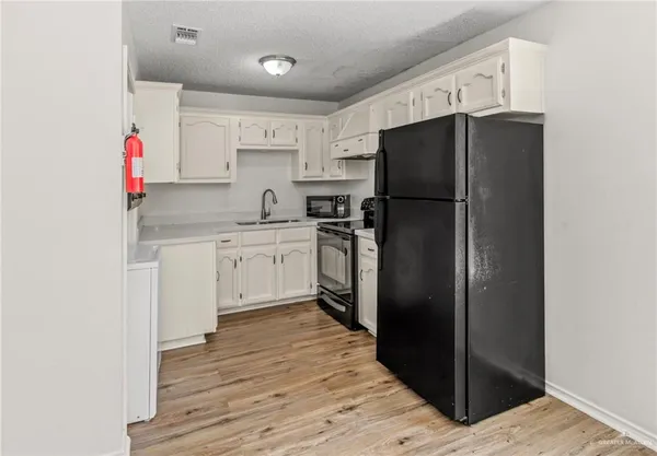 a kitchen with a refrigerator and a sink