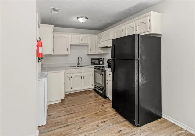 a kitchen with a refrigerator and a sink