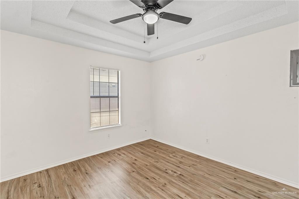 4601 South 24th Street, Unit 3 McAllen, TX 78503 - Photo 7 of 9 an empty room with wooden floor chandelier fan and windows