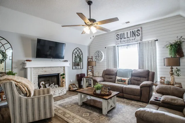 a living room with furniture a flat screen tv and a fireplace
