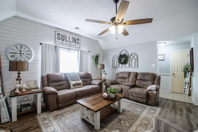 a living room with furniture and a wooden floor