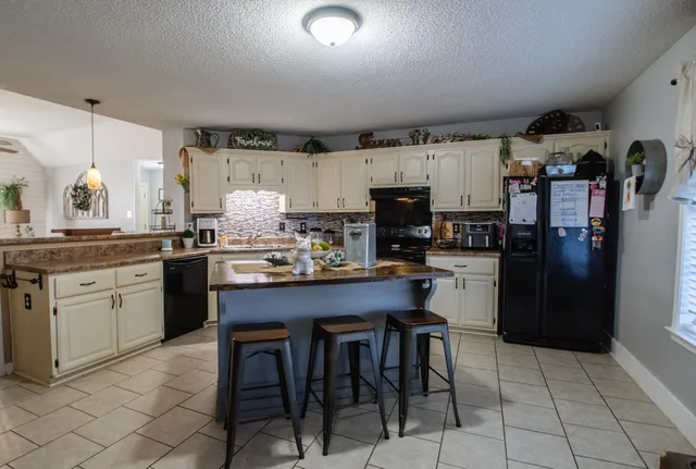 a kitchen with refrigerator cabinets and chairs