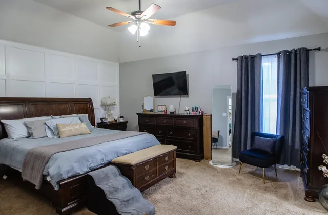 a bedroom with a bed and a flat screen tv