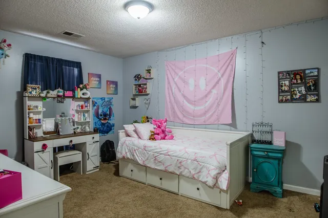a bedroom with a bed and a desk in it
