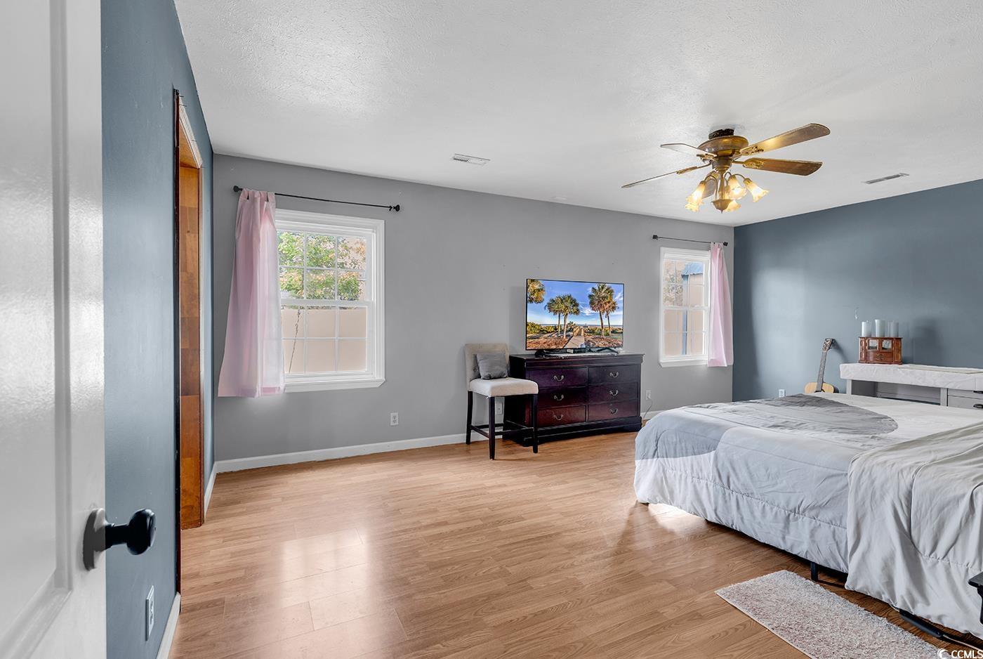 4 Plantation Road Myrtle Beach, SC 29588 - Photo 13 of 40 Bedroom with light wood-style floors, a ceiling fan, and a textured ceiling