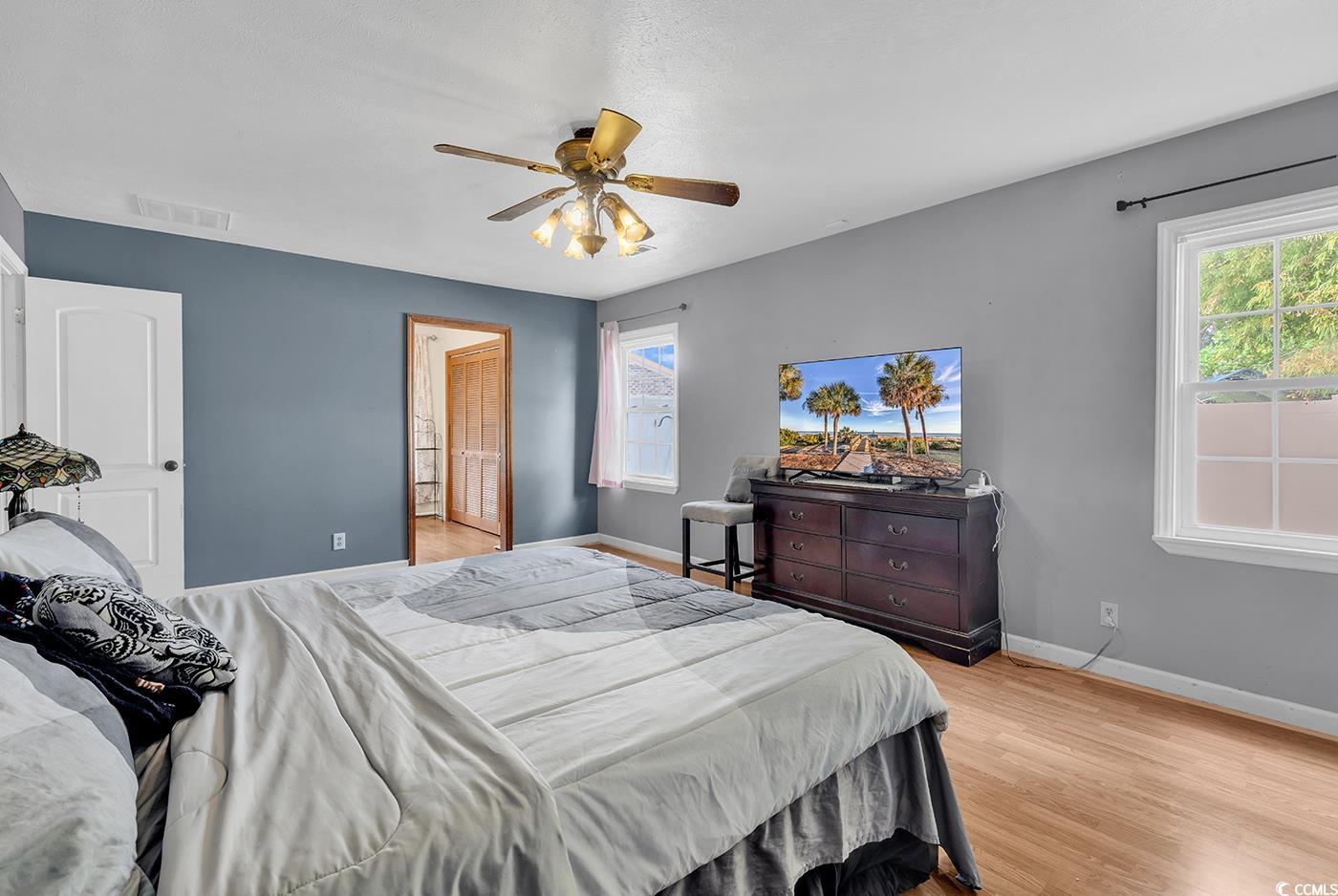 4 Plantation Road Myrtle Beach, SC 29588 - Photo 15 of 40 Bedroom with multiple windows, light wood finished floors, and a ceiling fan