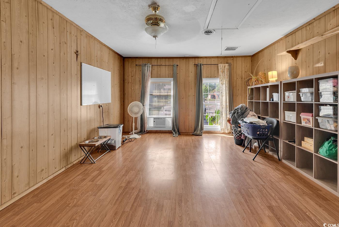 4 Plantation Road Myrtle Beach, SC 29588 - Photo 26 of 40 Office with attic access, wooden walls, light wood-style flooring, and crown molding