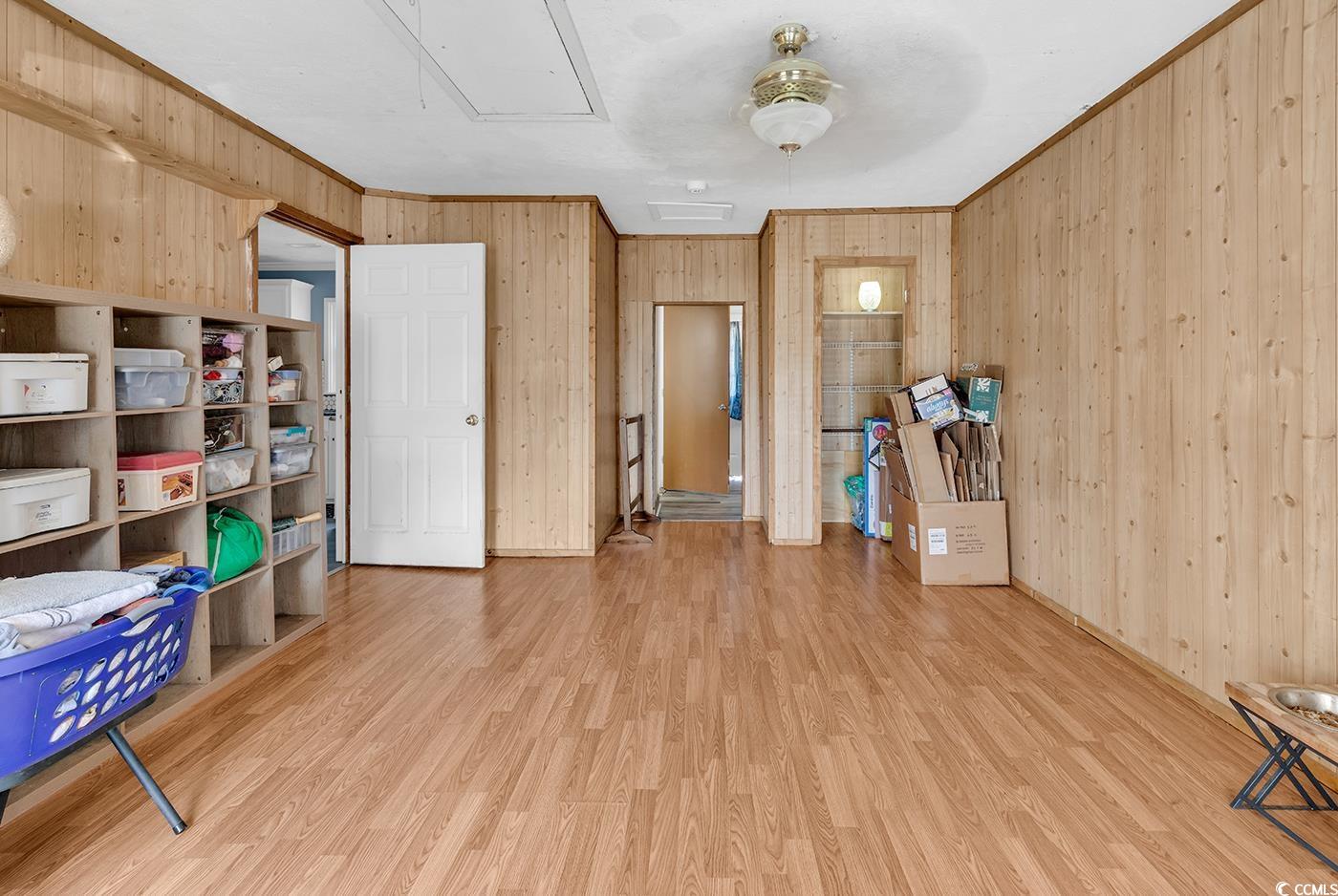 4 Plantation Road Myrtle Beach, SC 29588 - Photo 27 of 40 Interior space with wood walls, wood finished floors, crown molding, and attic access