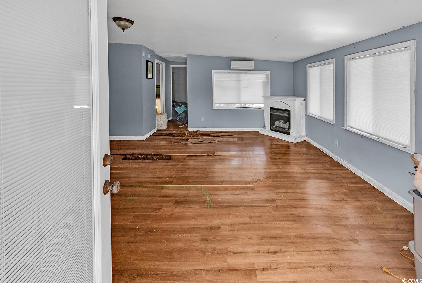 4 Plantation Road Myrtle Beach, SC 29588 - Photo 31 of 40 Unfurnished living room with light wood-style flooring and a fireplace