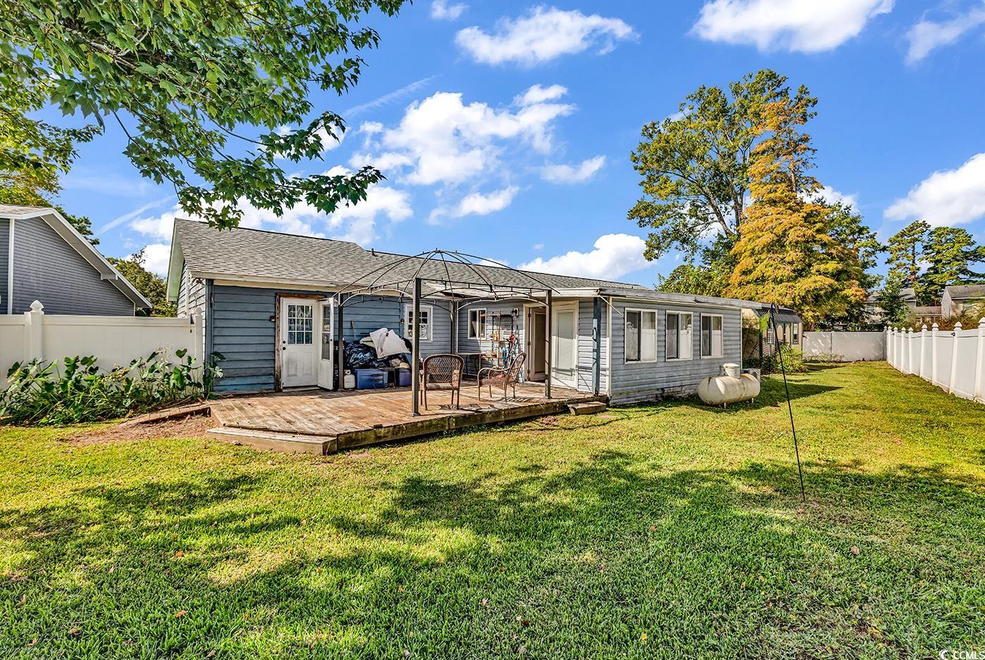 4 Plantation Road Myrtle Beach, SC 29588 - Photo 36 of 40 Rear view of property with a fenced backyard, a deck, and a shingled roof