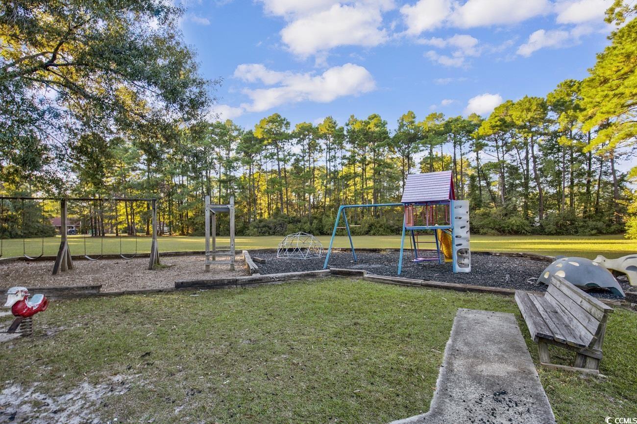 4 Plantation Road Myrtle Beach, SC 29588 - Photo 38 of 40 Community playground with view of scattered trees and a lawn