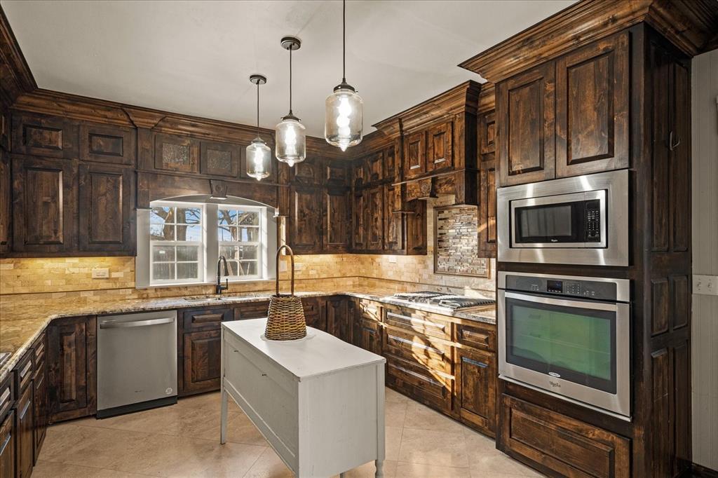 601 North Main Street Leonard, TX 75452 - Photo 10 of 34 a kitchen with stainless steel appliances granite countertop a sink and stove top oven