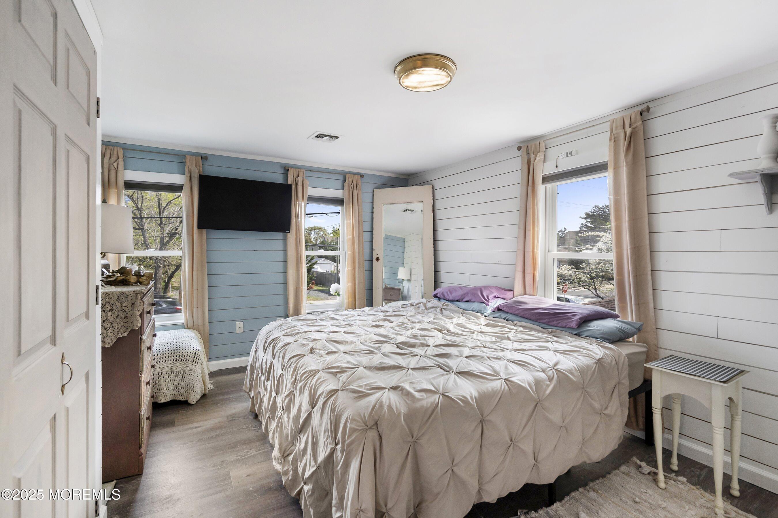 1030 Ocean Road Point Pleasant, NJ 08742 - Photo 18 of 45 a bed sitting in a spacious bedroom next to a window and a flat screen tv