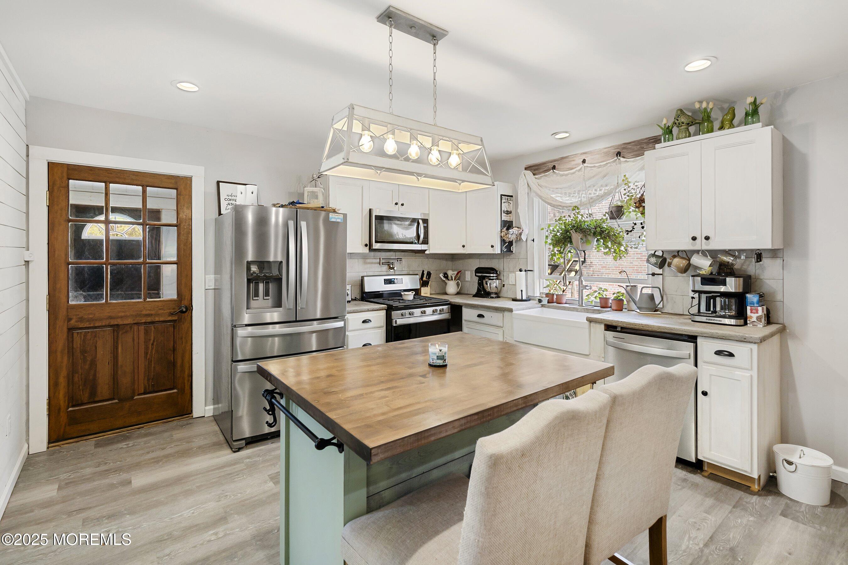 1030 Ocean Road Point Pleasant, NJ 08742 - Photo 9 of 45 a kitchen with a center island wooden floor and stainless steel appliances