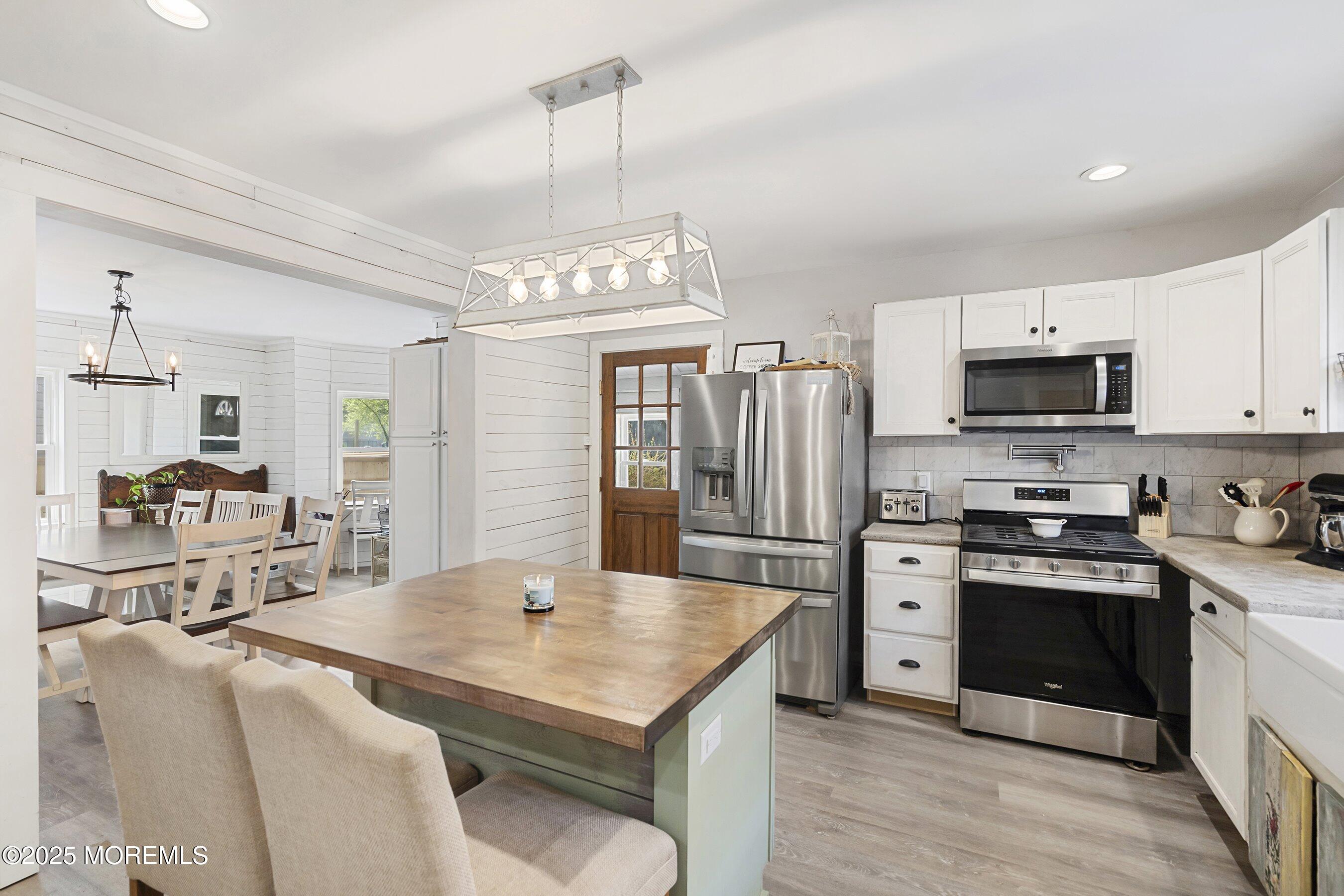 1030 Ocean Road Point Pleasant, NJ 08742 - Photo 10 of 45 a kitchen with stainless steel appliances granite countertop a sink a stove a refrigerator cabinets and a dining table