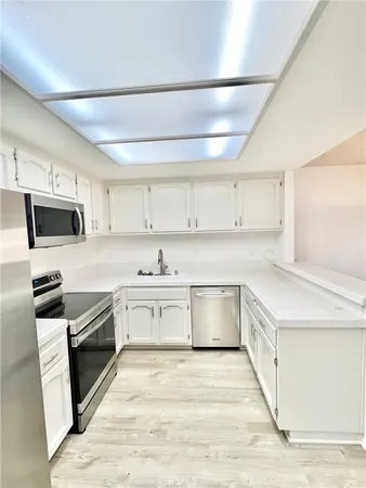 a kitchen with granite countertop a sink and steel appliances