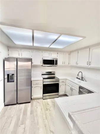 a kitchen with granite countertop a refrigerator and a sink