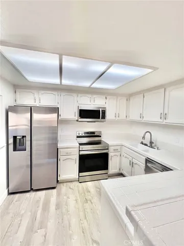 a kitchen with granite countertop a refrigerator and a sink