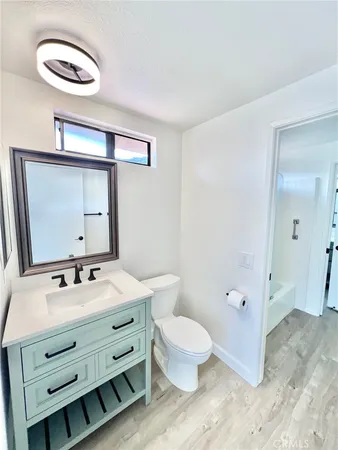 a bathroom with a sink a toilet and mirror