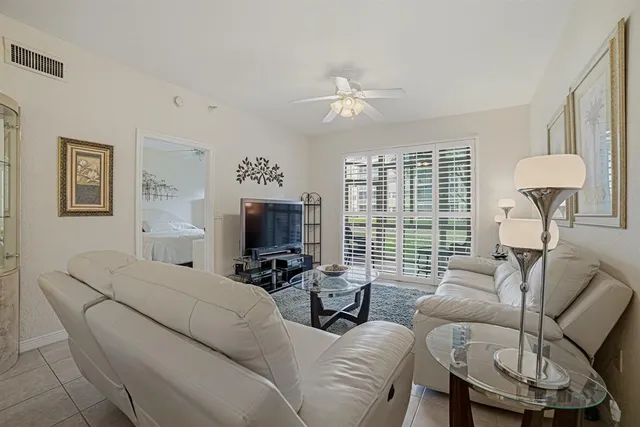a living room with furniture a large window and a flat screen tv