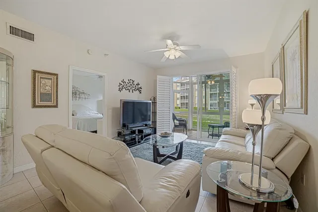 a living room with furniture a large window and a flat screen tv