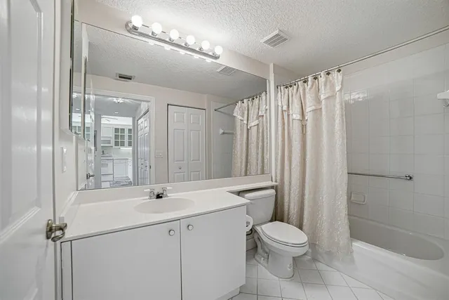 a bathroom with a shower sink vanity mirror and toilet