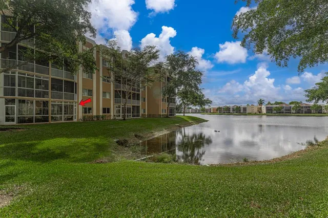a view of a lake with a big yard and potted plants and large trees