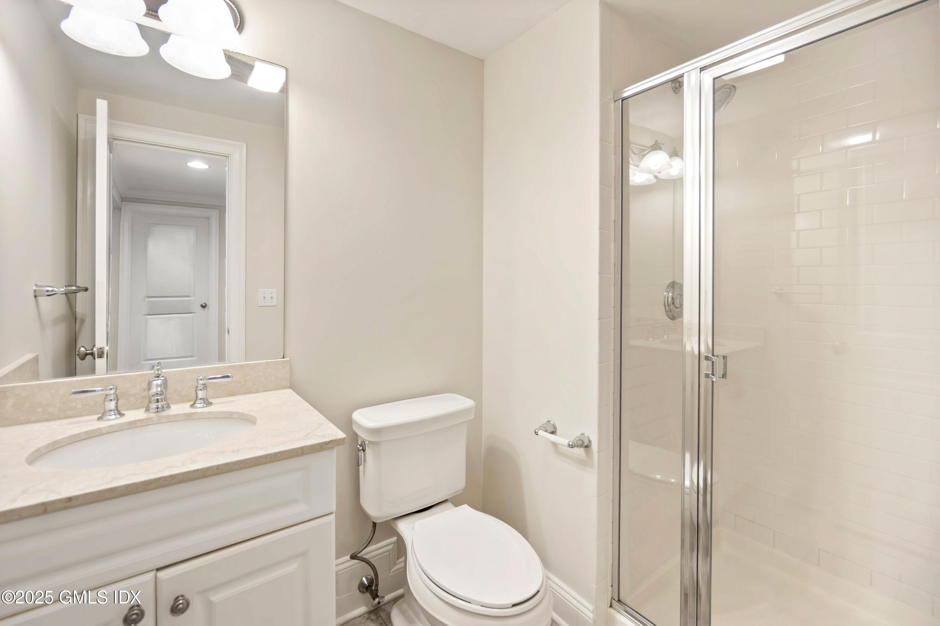 221 Weaver Street, Unit 19C Greenwich, CT 06831 - Photo 5 of 23 a bathroom with a toilet a sink and mirror