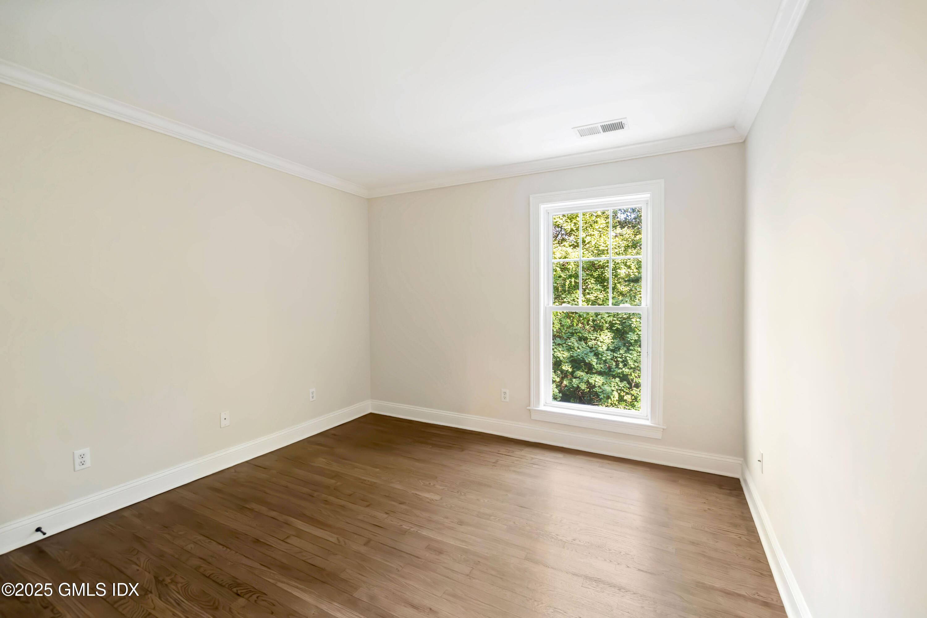 221 Weaver Street, Unit 19C Greenwich, CT 06831 - Photo 6 of 23 an empty room with wooden floor and windows