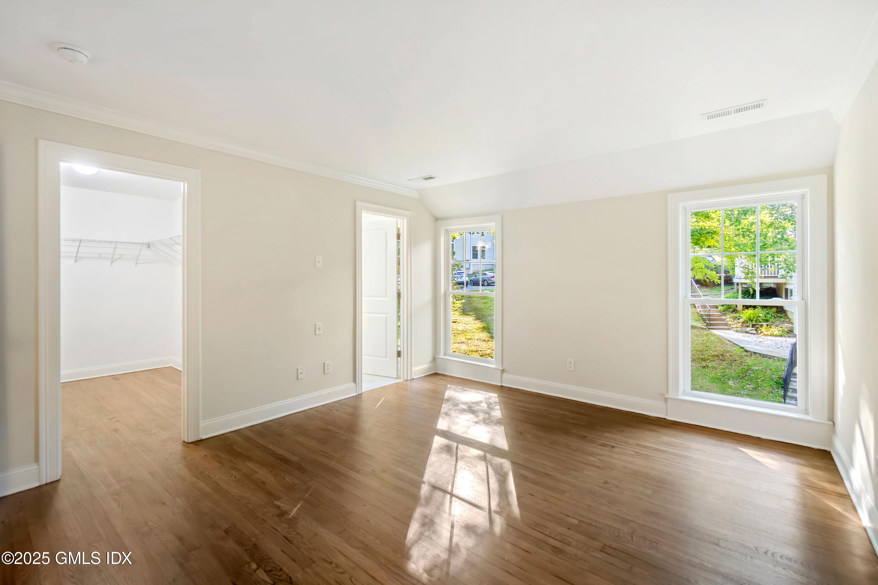 221 Weaver Street, Unit 19C Greenwich, CT 06831 - Photo 8 of 23 an empty room with wooden floor and windows