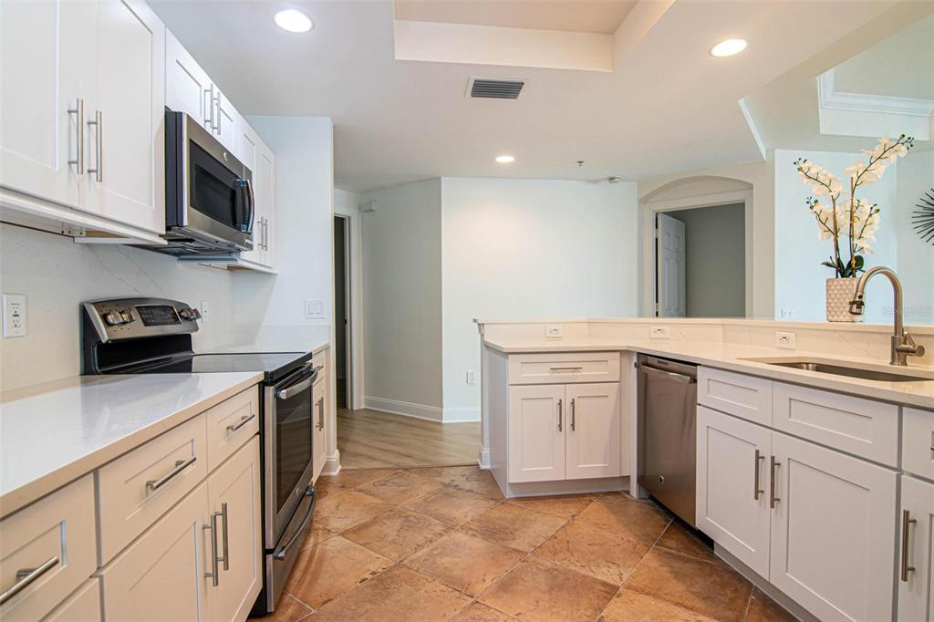2743 First Street, Unit 406 Fort Myers, FL 33916 - Photo 13 of 52 a kitchen with white cabinets and appliances