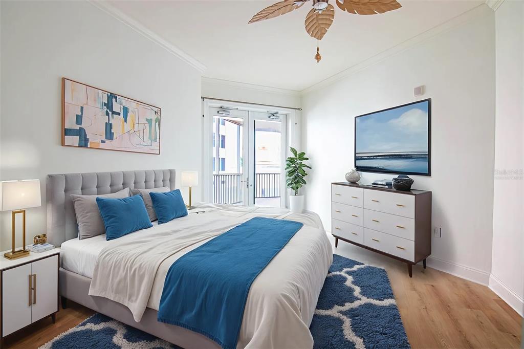 2743 First Street, Unit 406 Fort Myers, FL 33916 - Photo 43 of 52 a bedroom with a bed and a flat tv screen on dresser