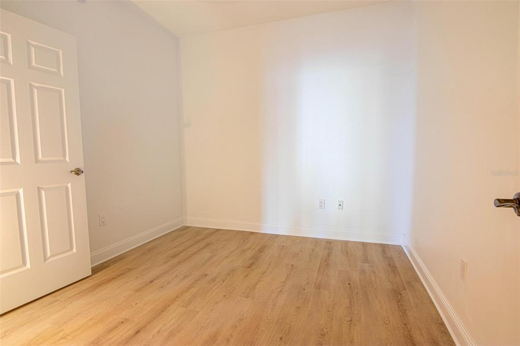 2743 First Street, Unit 406 Fort Myers, FL 33916 - Photo 50 of 52 an empty room with wooden floor