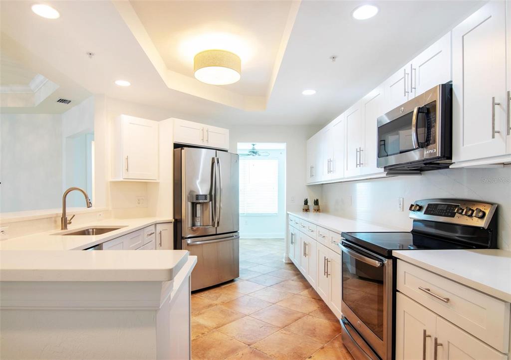 2743 First Street, Unit 406 Fort Myers, FL 33916 - Photo 9 of 52 a kitchen with stainless steel appliances granite countertop a refrigerator sink and microwave