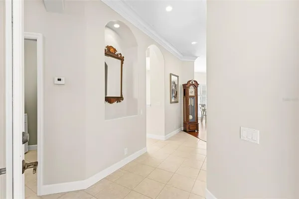a dining room with wooden floor a chandelier a glass table and chairs