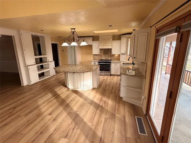 a kitchen with stainless steel appliances a refrigerator and wooden floor