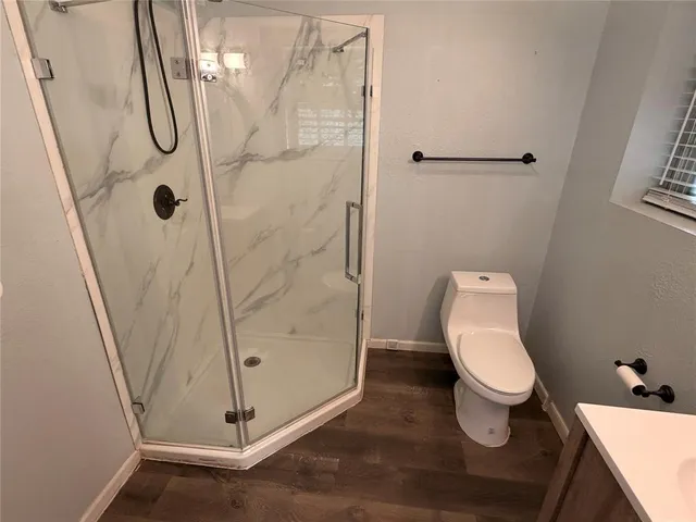 a white toilet sitting next to a shower