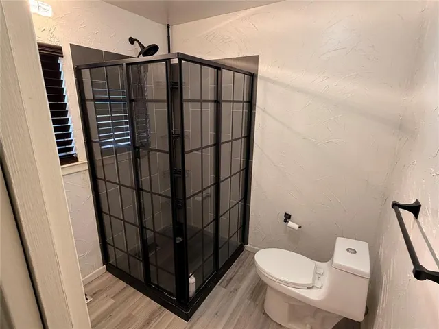a bathroom with a toilet and a shower