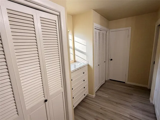 a view of a hallway with wooden floor and staircase