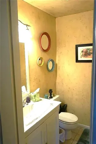 a bathroom with a granite countertop toilet sink and mirror