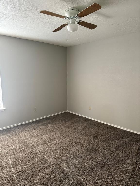 304 East Hickory Street, Unit B Kaufman, TX 75142 - Photo 7 of 14 an empty room with a ceiling fan and window