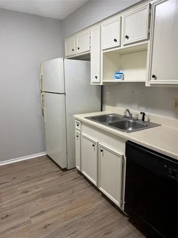 a kitchen with a sink a refrigerator and cabinets