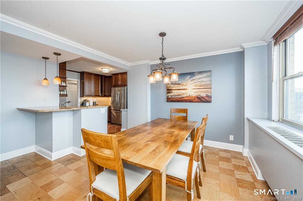 50 Glenbrook Road, Unit 6E Stamford, CT 06902 - Photo 7 of 18 a view of a dining room with furniture a chandelier and wooden floor