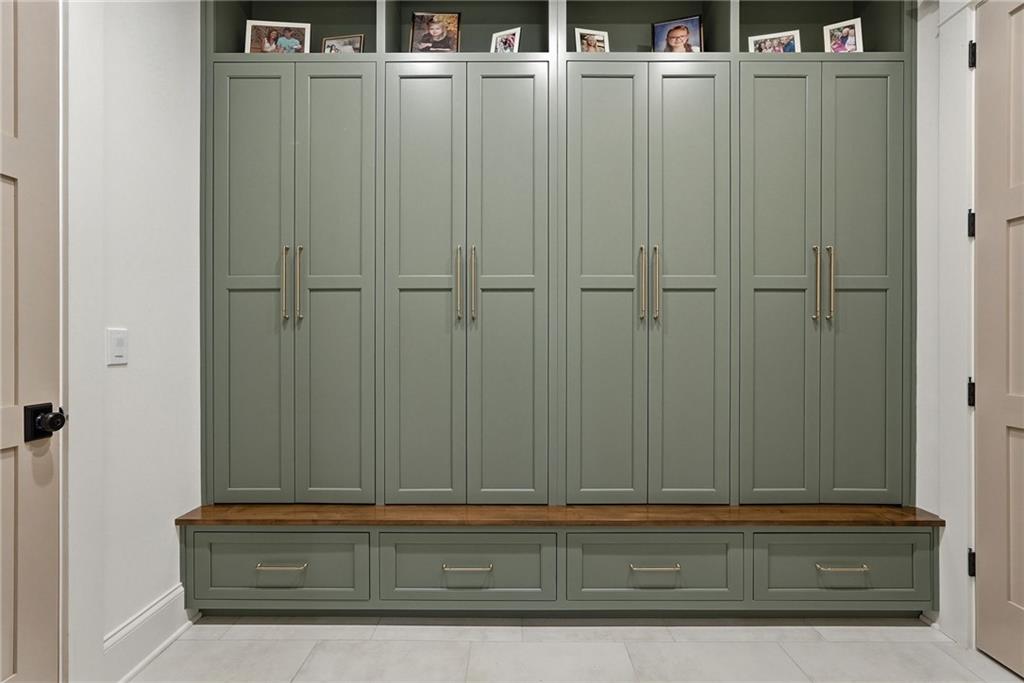 225 Stoup Road Mars, PA 16046 - Photo 22 of 50 The mudroom off the four-car garage features floor-to-ceiling sage green built-in lockers with brass hardware, a wood bench, and lower drawers — keeping everything organized from the moment you walk in. Each locker is equipped with its own outlet.