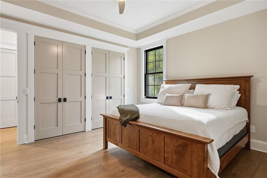 225 Stoup Road Mars, PA 16046 - Photo 25 of 50 The main level bedroom features a tray ceiling, double closets, black-framed windows, 9-inch engineered white oak hardwood floors, and a private en-suite — a versatile space well suited for guests or multi-generational living.