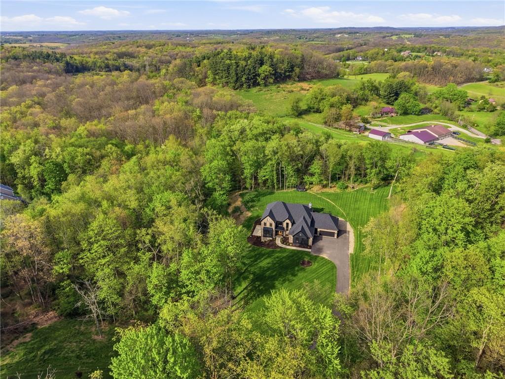 225 Stoup Road Mars, PA 16046 - Photo 3 of 50 An aerial view tells the full story — 225 Stoup Road is tucked privately among 6.45 acres of wooded surroundings, with a sweeping curved driveway, manicured lawn, and open farmland and rolling Western Pennsylvania countryside stretching out beyond.